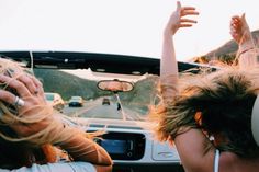 two women sitting in the back of a car and one is holding her head up