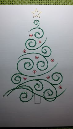 a drawing of a christmas tree with green and red swirls on white paper,