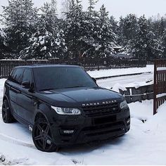 a black range rover is parked in the snow