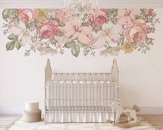 a baby crib in front of a floral wall mural