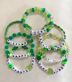 four bracelets that say lucky, lucky and lucky with green beaded beads on them