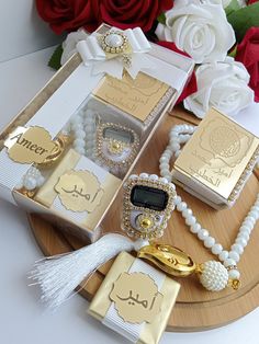 an assortment of jewelry is displayed on a tray with red roses in the back ground