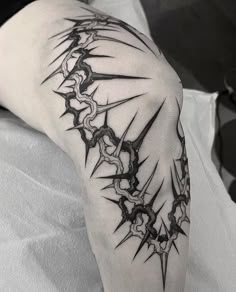 a man's arm with black and white tattoos on it, including an intricate design