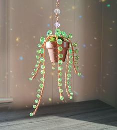 a potted plant with green beads hanging from it