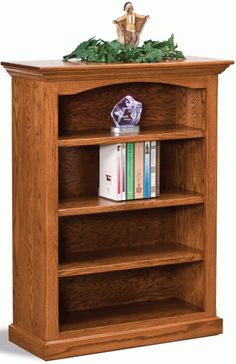 an oak bookcase with three shelves and two plates on top