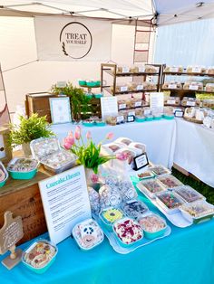 there is a table full of food on display at this outdoor event with flowers in the center