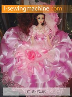 the doll is wearing a pink dress and holding a rose in her hand while sitting on a chair