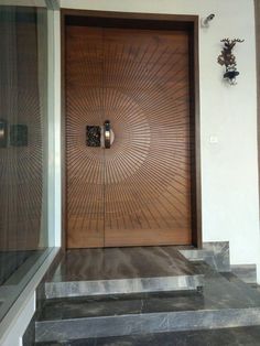 a wooden door sitting on the side of a white wall next to some stone steps