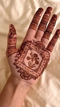 a person's hand with hennap on it and flowers in the middle