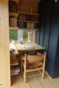 there is a table and chairs in the room with bookshelves on the wall