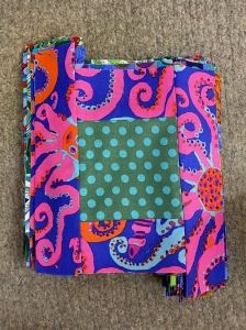 an open notebook covered in pink, blue and green fabric