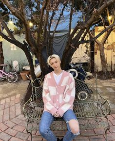 a young man sitting on top of a metal bench