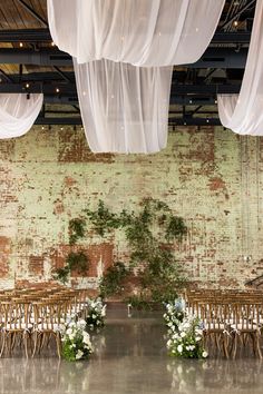 an indoor wedding setup with white flowers and greenery