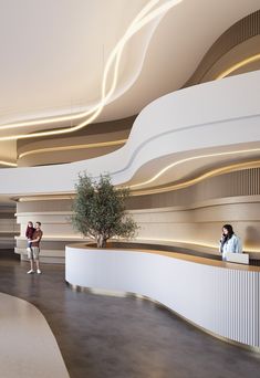 two people are standing at the counter in an office building with curved ceilings and white walls