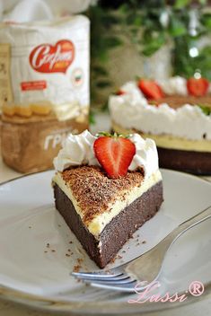 a piece of cake with whipped cream and strawberries on top is sitting on a plate