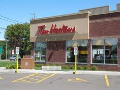 the front of a store called tim horton's on a street corner in an empty parking lot