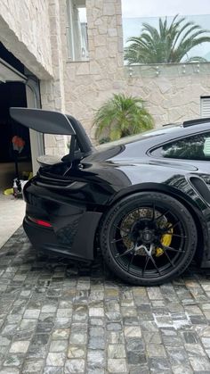 a black sports car parked in front of a garage