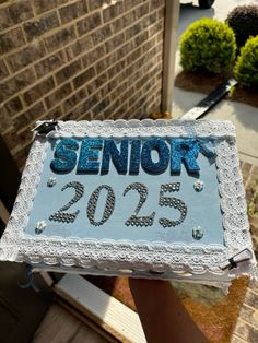 a cake with the word senior on it is being held by someone's hand