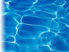 blue water with ripples in the middle and light reflecting off it's surface