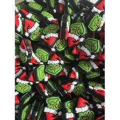 a pile of green and red christmas themed candy canes with the grin face on them