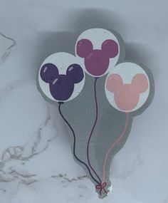 a pair of mickey mouse balloons sitting on top of a white tablecloth covered floor