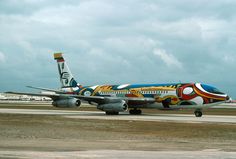 an airplane painted with colorful designs on the tarmac