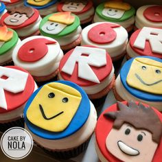 cupcakes decorated with faces and letters are displayed