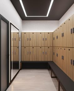 an empty locker room with wooden lockers and black benches in the center, all lined up