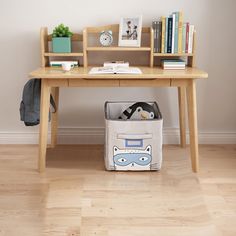 a wooden desk with a book case and books on it next to a small shelf