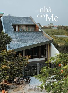 a house with two bikes parked in front of it and the words'n ha cua me on top