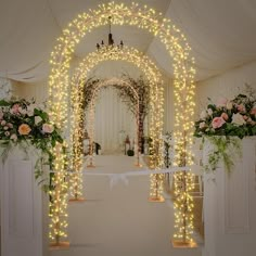 an archway decorated with lights and flowers