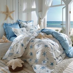 a bed with blue and white comforters on top of it next to a window