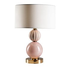 a table lamp with a white shade on top and a light pink glass ball at the base