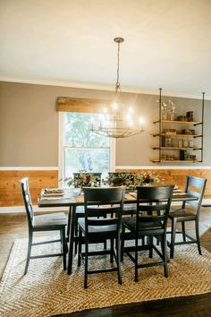 a dinning room table with chairs and a chandelier hanging from the ceiling