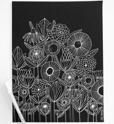 a black and white drawing of flowers on a piece of paper with a marker next to it