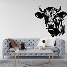 a living room with a couch, table and cow wall decal