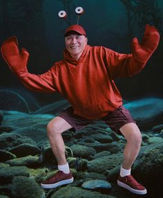 a man in red shirt and hat standing on rocks