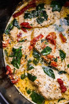 chicken with spinach and tomato sauce in the slow cooker, ready to be cooked