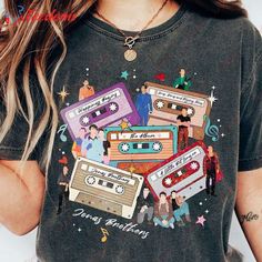 a woman wearing a t - shirt with cassette tapes on it