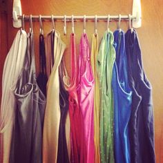 there are many different colored dresses hanging on the rack