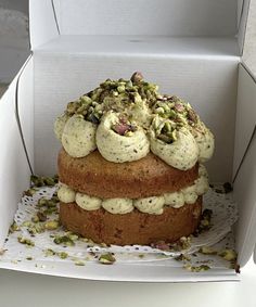 a cake in a box with pistachios on top