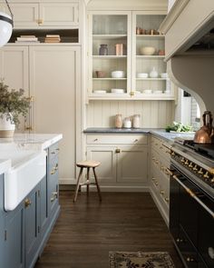 a kitchen with blue cabinets and white counter tops, gold trim on the drawers and brass knobs