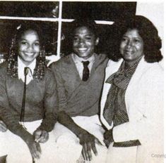 three women sitting next to each other in front of a window smiling at the camera