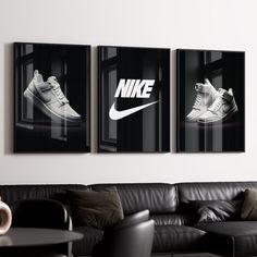 three black and white posters hang on the wall above a couch in a living room