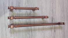 three metal handles on a wooden surface