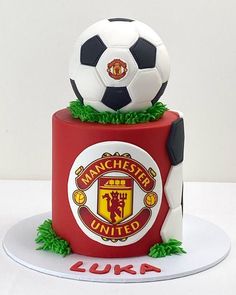 a cake with a soccer ball on top of it and the words manchester united written in red