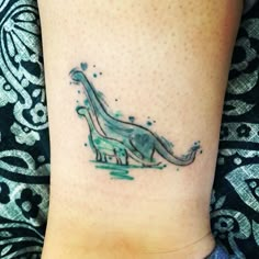 a small dinosaur tattoo on the ankle