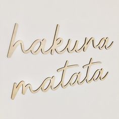 the word hakuuna matata is cut out of wood and placed on a white surface