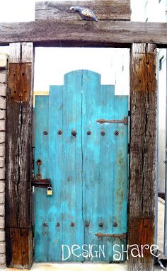 an old blue door is open in front of a brick wall and wooden structure with the words design share on it