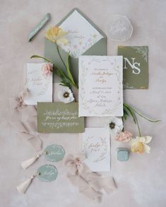 the wedding stationery is laid out with flowers